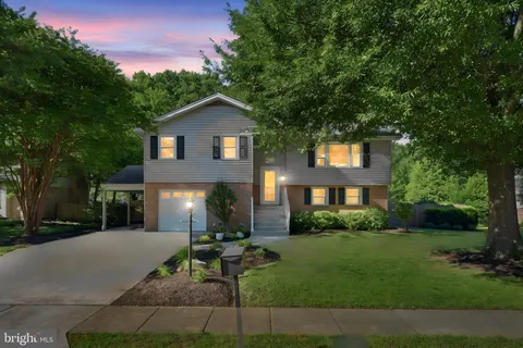a front view of a house with a yard and green space