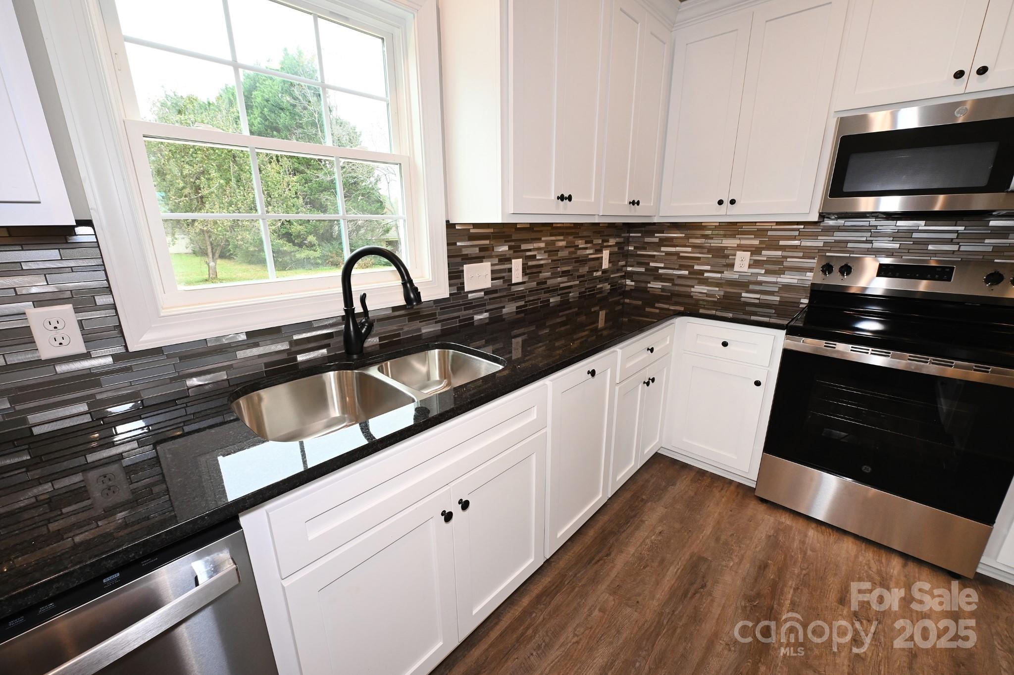 3835 Sulphur Springs Road Northeast Hickory, NC 28601 - Photo 12 of 44 a kitchen with granite countertop a stove a sink and a microwave