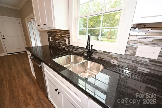 a kitchen with granite countertop a sink and a stove