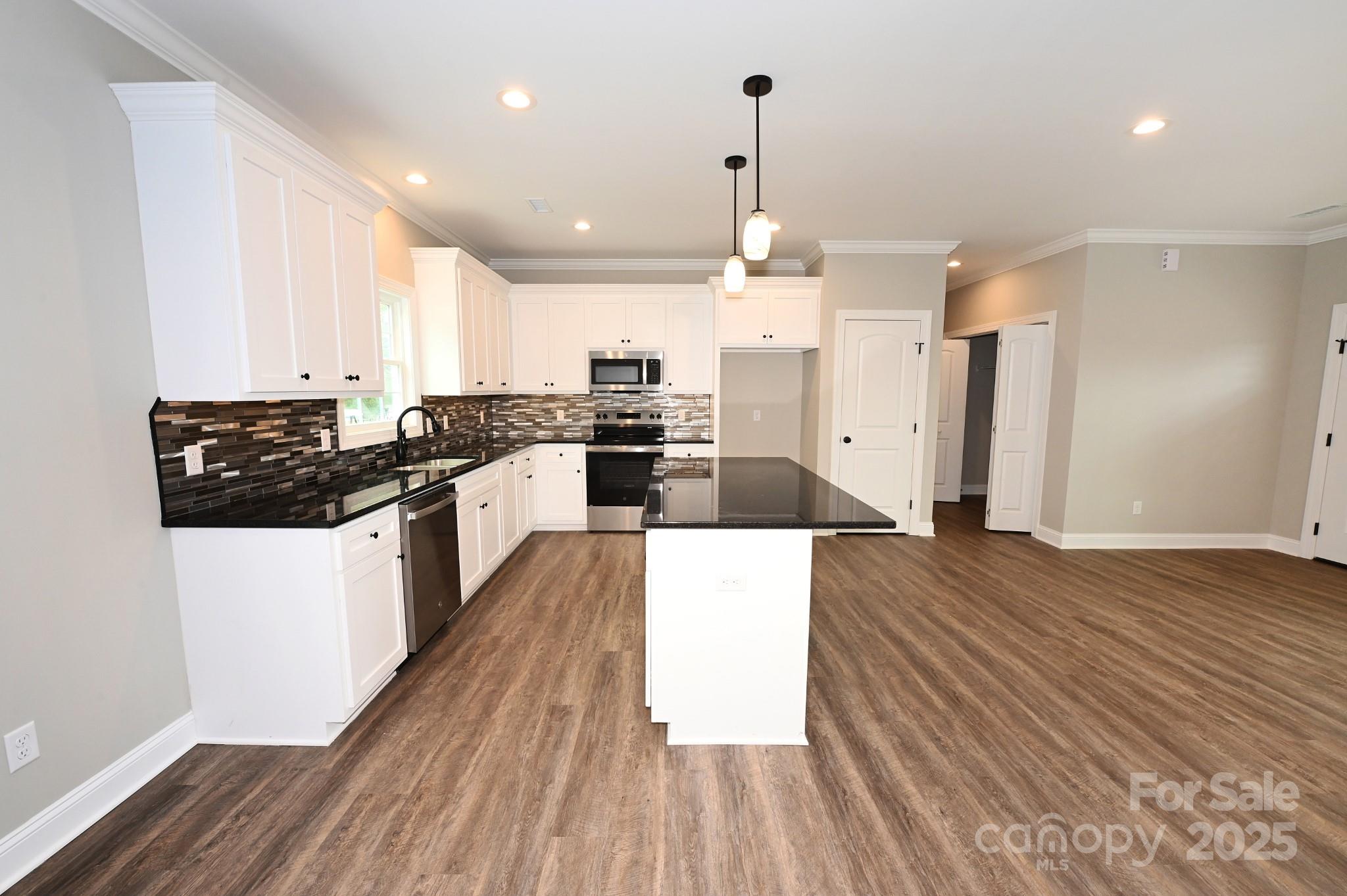 3835 Sulphur Springs Road Northeast Hickory, NC 28601 - Photo 18 of 44 a kitchen with stainless steel appliances a stove top oven a sink dishwasher and a refrigerator with wooden floor