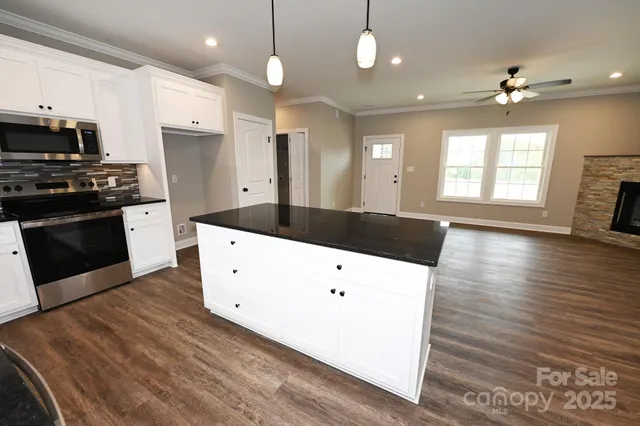 a large kitchen with a wooden floor and a stove top oven