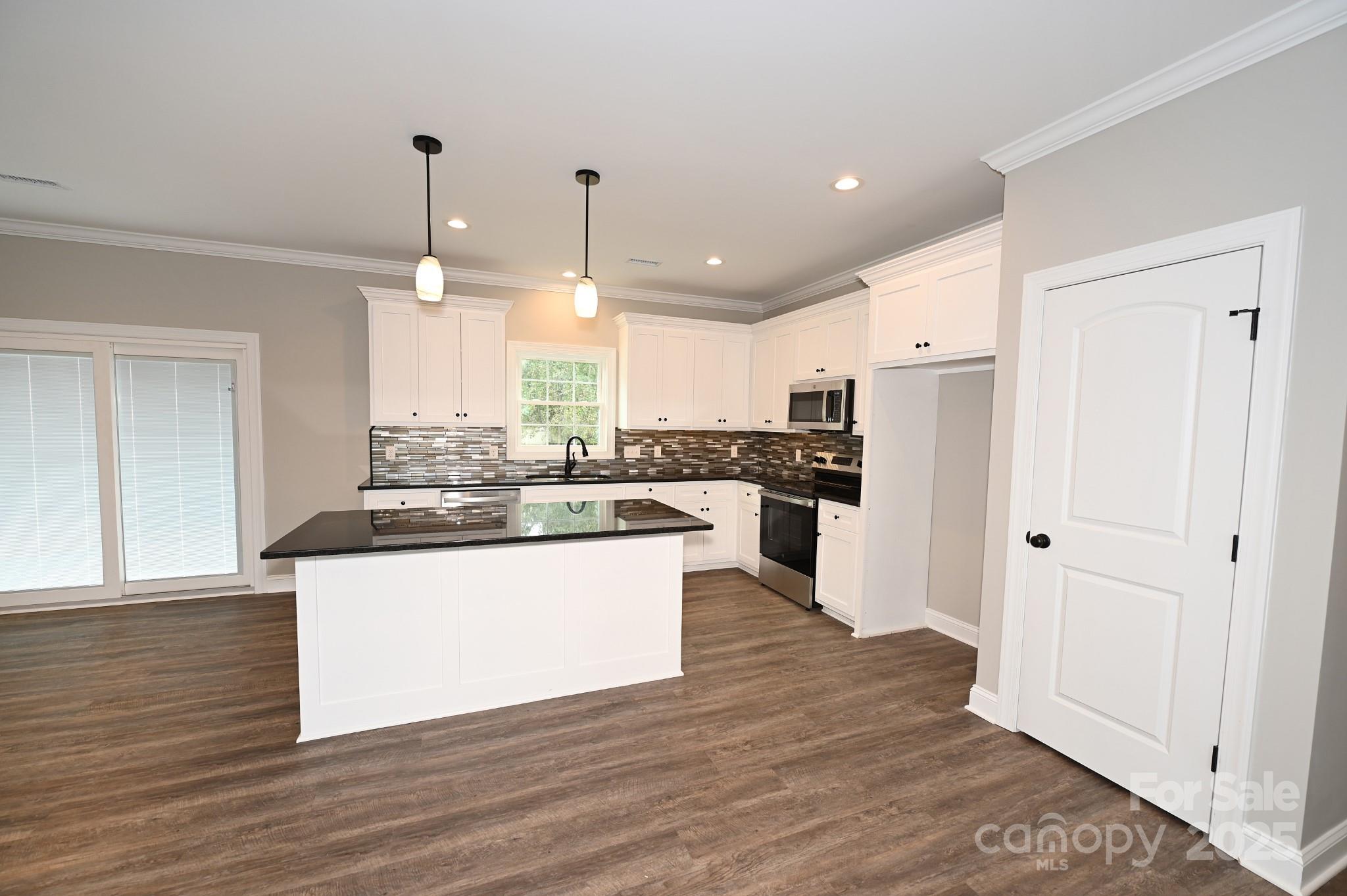 3835 Sulphur Springs Road Northeast Hickory, NC 28601 - Photo 20 of 44 a large kitchen with stainless steel appliances kitchen island a large counter top and wooden floors