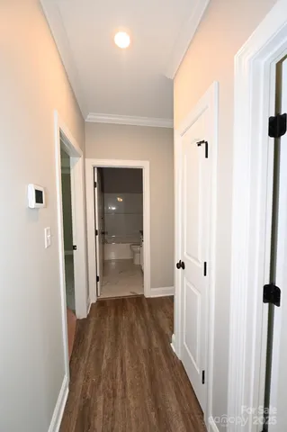 a view of a hallway with wooden floor and closet area
