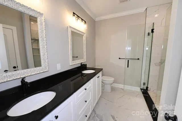 a bathroom with a granite countertop sink toilet a mirror and shower