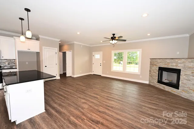 a view of a kitchen with a sink wooden floor and a fireplace