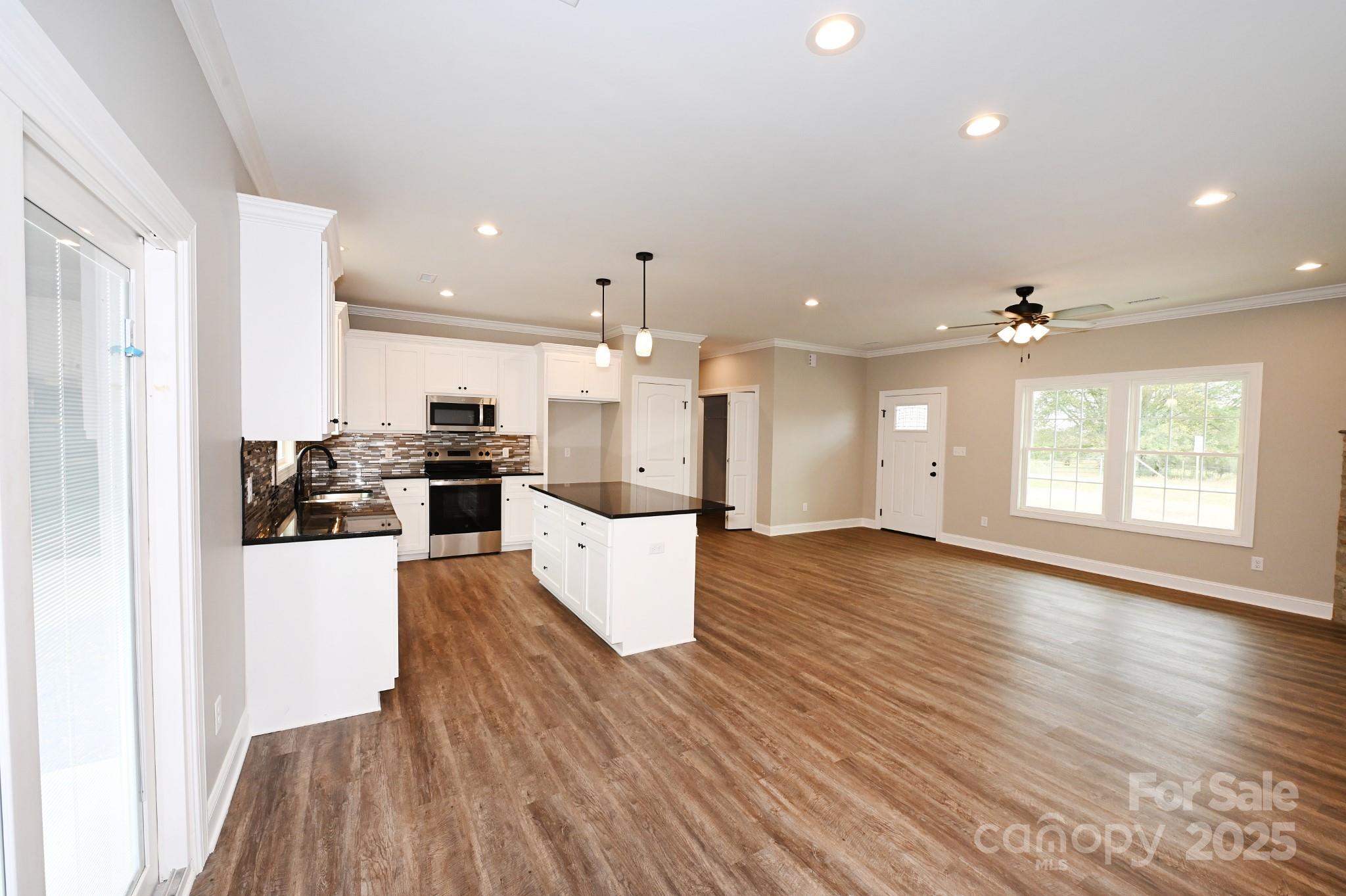 3835 Sulphur Springs Road Northeast Hickory, NC 28601 - Photo 7 of 44 a large kitchen with kitchen island a stove a refrigerator cabinets and wooden floor