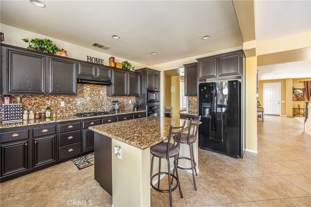 18936 Malkoha Street Perris, CA 92570 - Photo 18 of 70 a kitchen with stainless steel appliances granite countertop a refrigerator and a sink