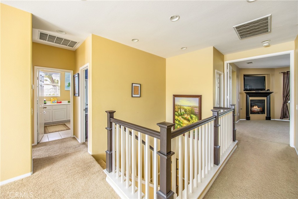 18936 Malkoha Street Perris, CA 92570 - Photo 30 of 70 a view of a hallway to a livingroom with wooden floor and staircase