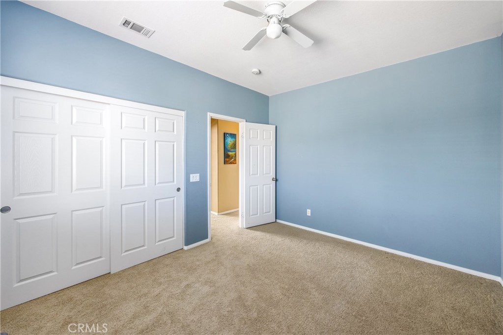 18936 Malkoha Street Perris, CA 92570 - Photo 39 of 70 an empty room with closet and a chandelier fan