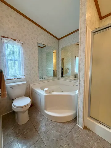 a bathroom with a granite countertop sink a toilet a mirror and bathtub