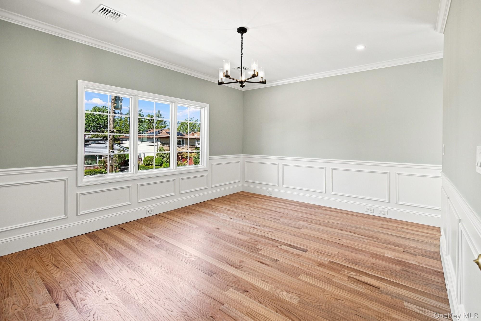 148 Latham Road Mineola, NY 11501 - Photo 19 of 27 Hardwood flooring, crown molding, wainscoting, recessed lighting.