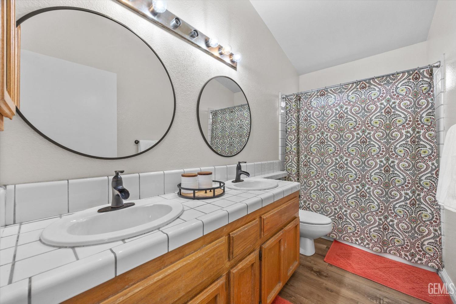 Undisclosed Address Bakersfield, CA 93312 - Photo 24 of 31 a bathroom with a sink a mirror and a shower