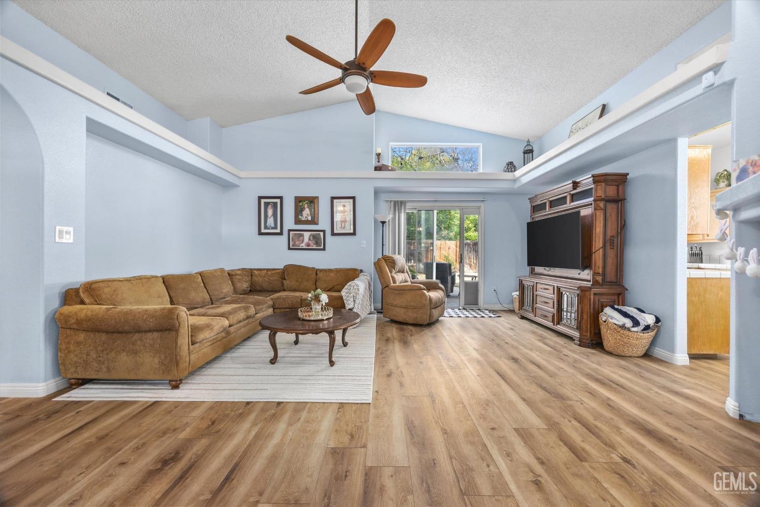 Undisclosed Address Bakersfield, CA 93312 - Photo 8 of 31 a living room with furniture a flat screen tv and a floor to ceiling window