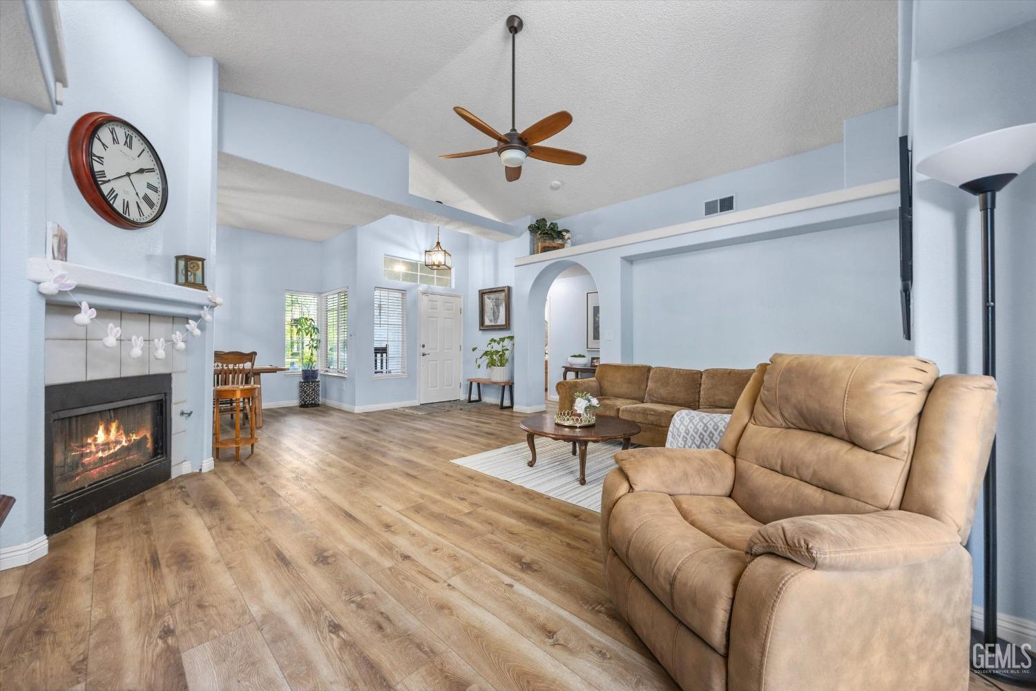 Undisclosed Address Bakersfield, CA 93312 - Photo 10 of 31 a living room with furniture a clock and a fireplace