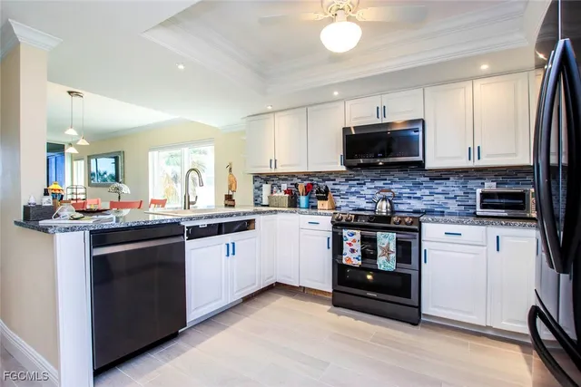 a kitchen with stainless steel appliances kitchen island granite countertop a stove top oven a sink dishwasher a dining table and chairs