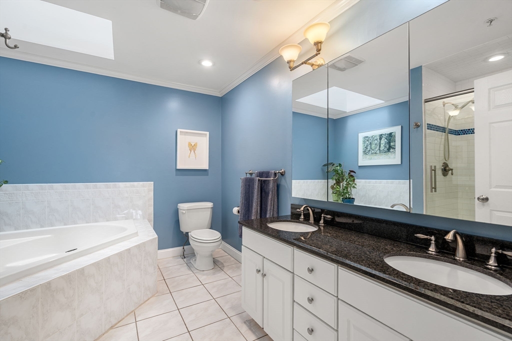 104 Harvard Street, Unit 6 Brookline, MA 02446 - Photo 11 of 18 a spacious bathroom with a granite countertop sink and a mirror