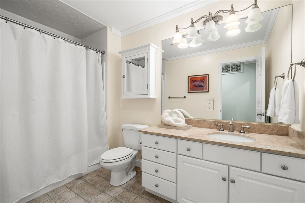 104 Harvard Street, Unit 6 Brookline, MA 02446 - Photo 14 of 18 a bathroom with a granite countertop sink mirror vanity and toilet