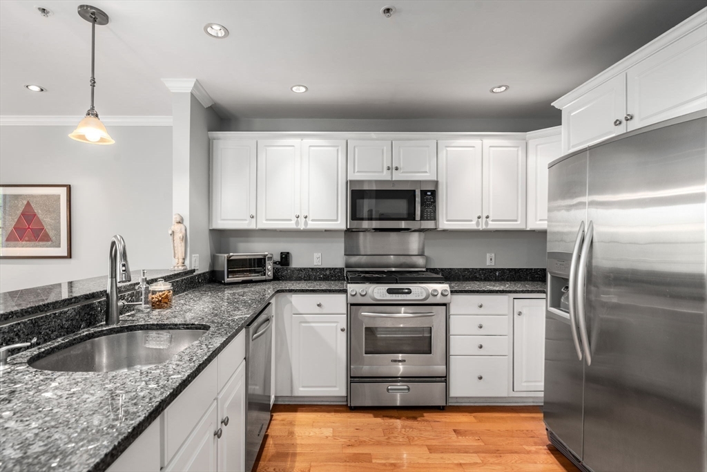 104 Harvard Street, Unit 6 Brookline, MA 02446 - Photo 5 of 18 a kitchen with stainless steel appliances granite countertop a sink stove and refrigerator