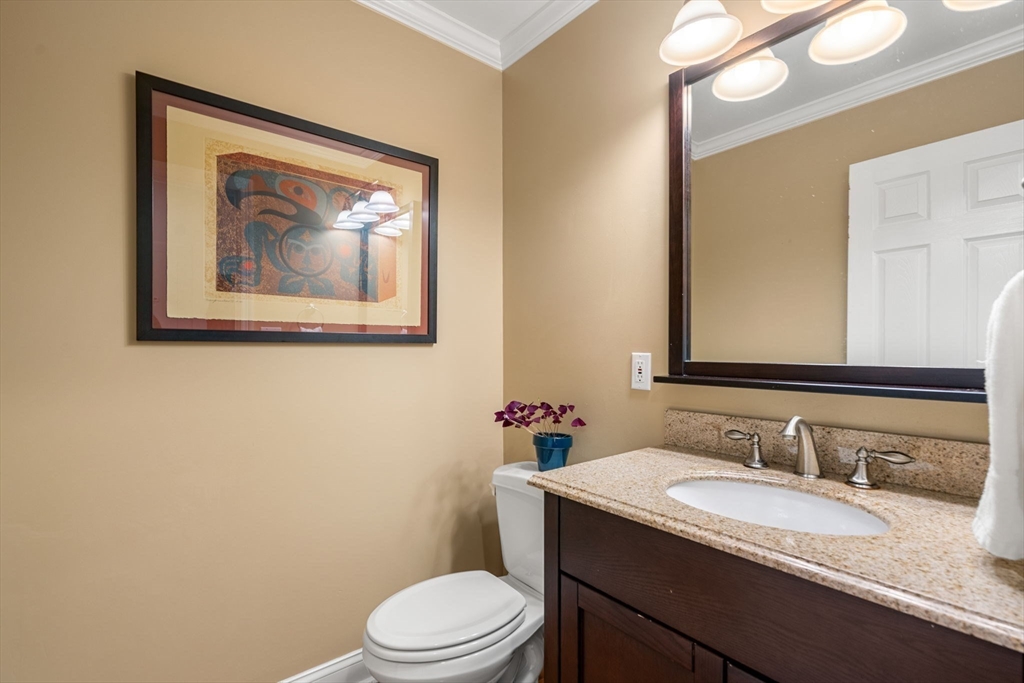 104 Harvard Street, Unit 6 Brookline, MA 02446 - Photo 7 of 18 a bathroom with a granite countertop toilet a sink and a mirror