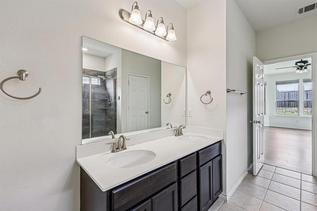 2712 Ryder Lane Aubrey, TX 76227 - Photo 12 of 26 a bathroom with a sink vanity and a mirror