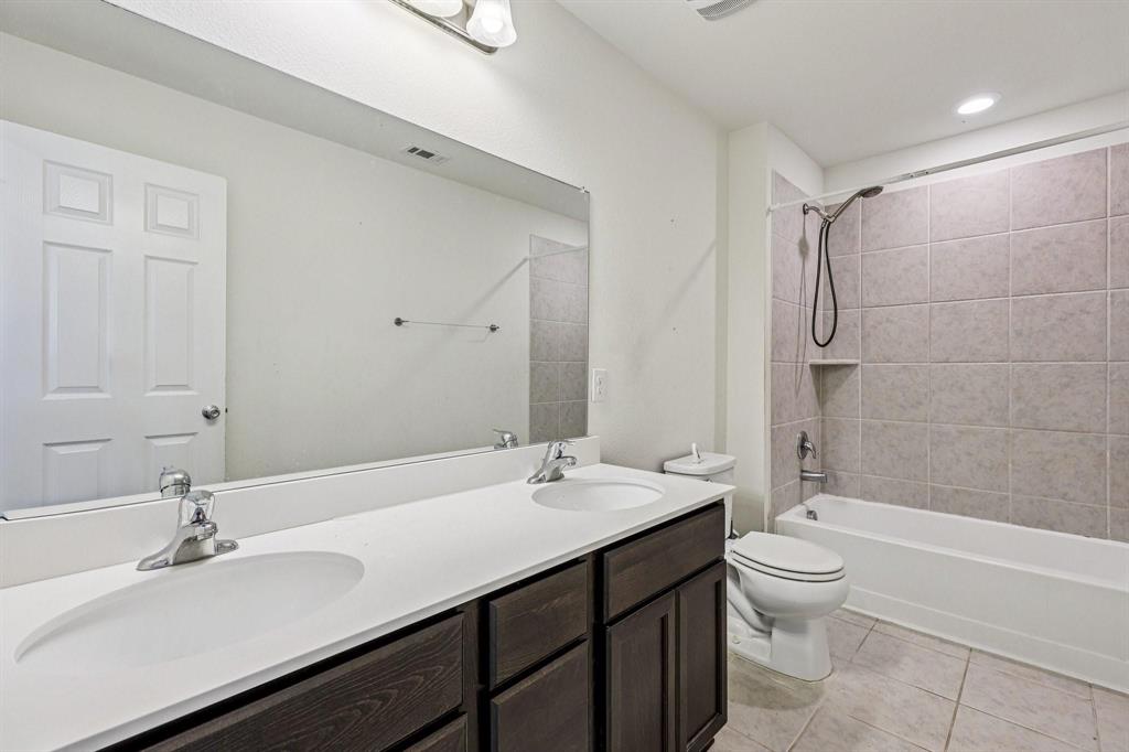 2712 Ryder Lane Aubrey, TX 76227 - Photo 17 of 26 a bathroom with a double vanity sink toilet and shower