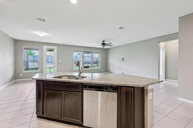 a kitchen with granite countertop kitchen island a sink and a stove