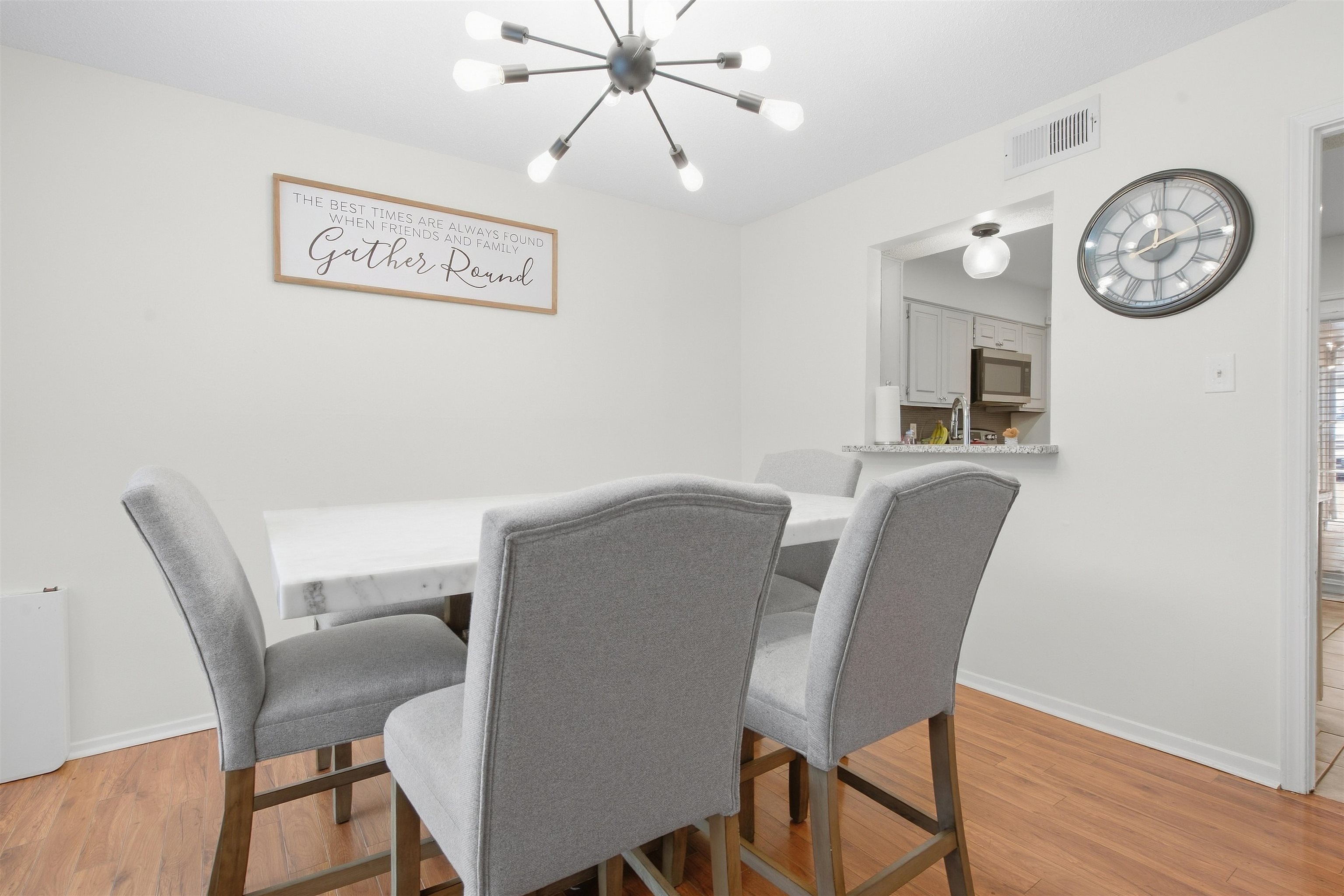 8367 Brownstone Lane, Unit 22 Cordova, TN 38016 - Photo 5 of 20 Wood-finish flooring, modern sputnik chandelier, white walls, and a pass-through to the kitchen featuring a built-in shelf