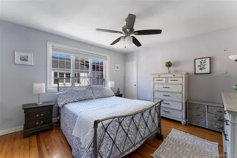 a bedroom with a bed a dresser and a window