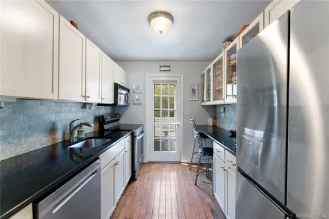 a kitchen with a sink a refrigerator and cabinets