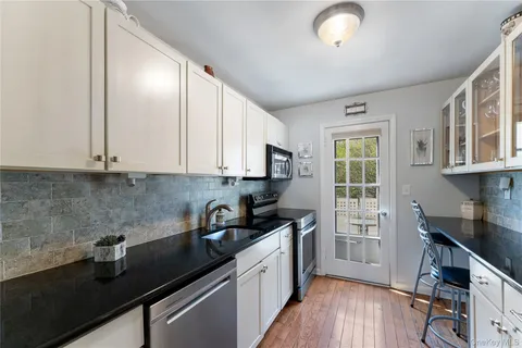 a kitchen with granite countertop a sink cabinets and wooden floor