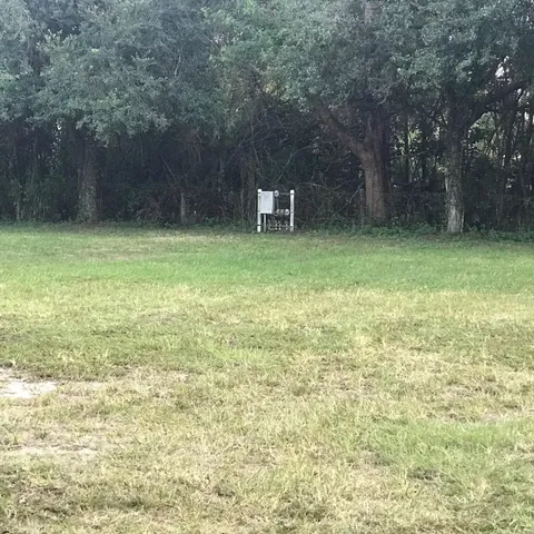 a backyard of a house with lots of green space and fountain