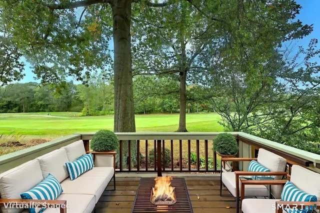 a view of a two chairs in the deck next to a yard