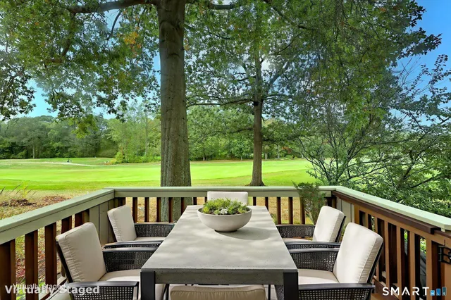a view of a city from a balcony with a table and chairs