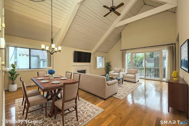 a dining room with furniture a chandelier and wooden floor