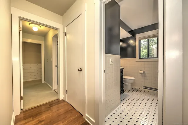 a bathroom with a granite countertop sink a toilet and a mirror