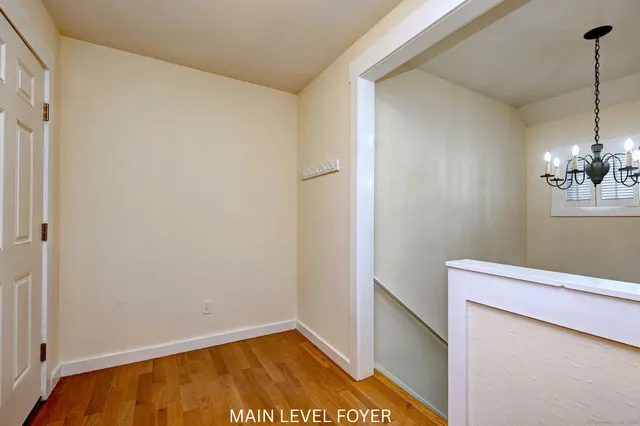 a view of staircase with wooden floor and white walls
