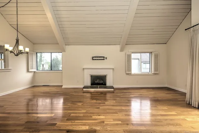 a view of an empty room with window and fire place