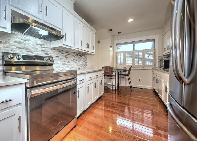 a kitchen with stainless steel appliances granite countertop a stove a sink and a refrigerator