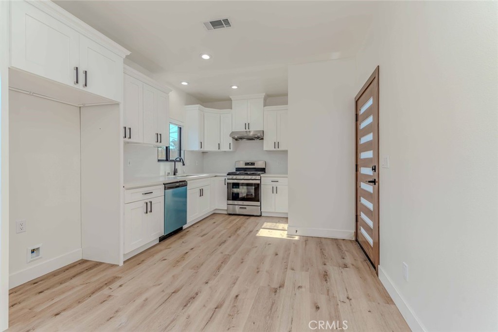 a kitchen with a refrigerator and white cabinets
