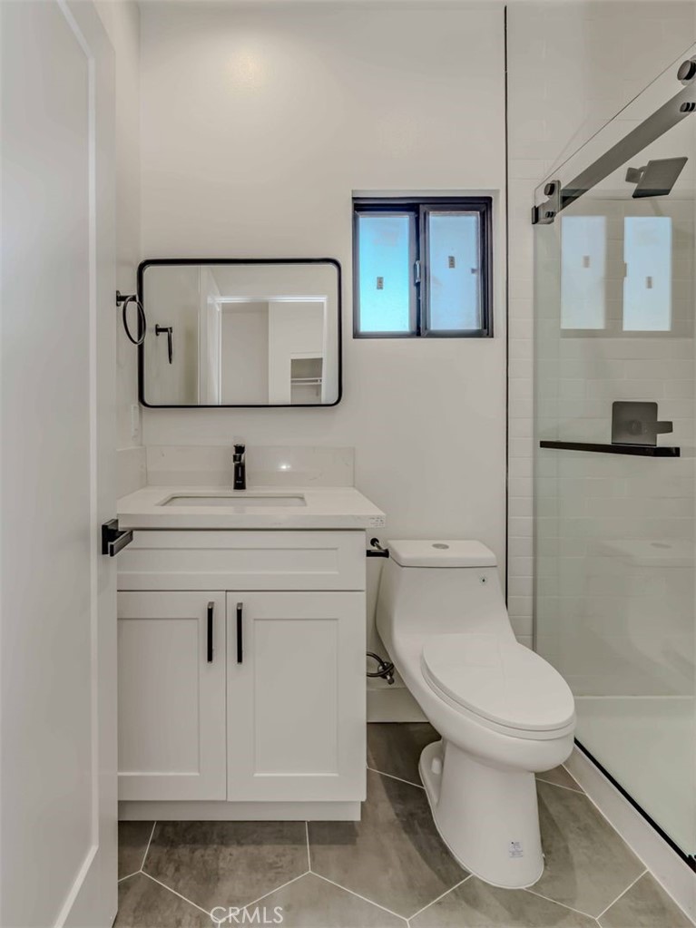5825 View Circle Huntington Beach, CA 92649 - Photo 14 of 28 a bathroom with a toilet sink vanity and mirror