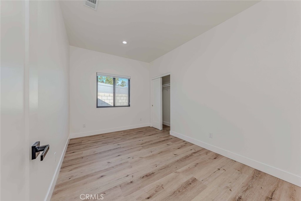 5825 View Circle Huntington Beach, CA 92649 - Photo 17 of 28 an empty room with wooden floor and windows
