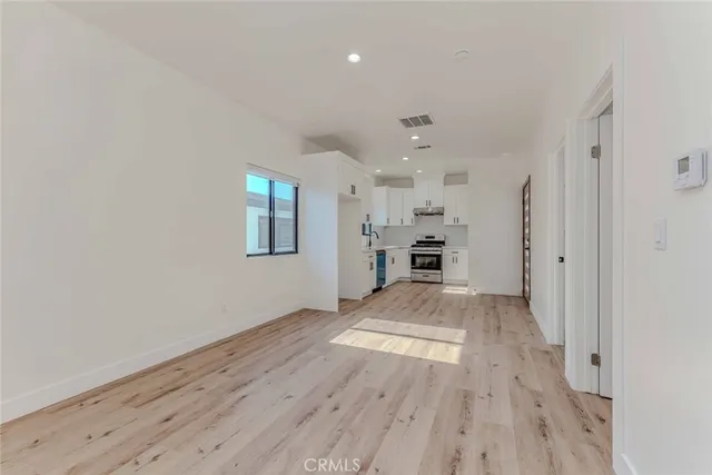 an empty room with wooden floor and closet