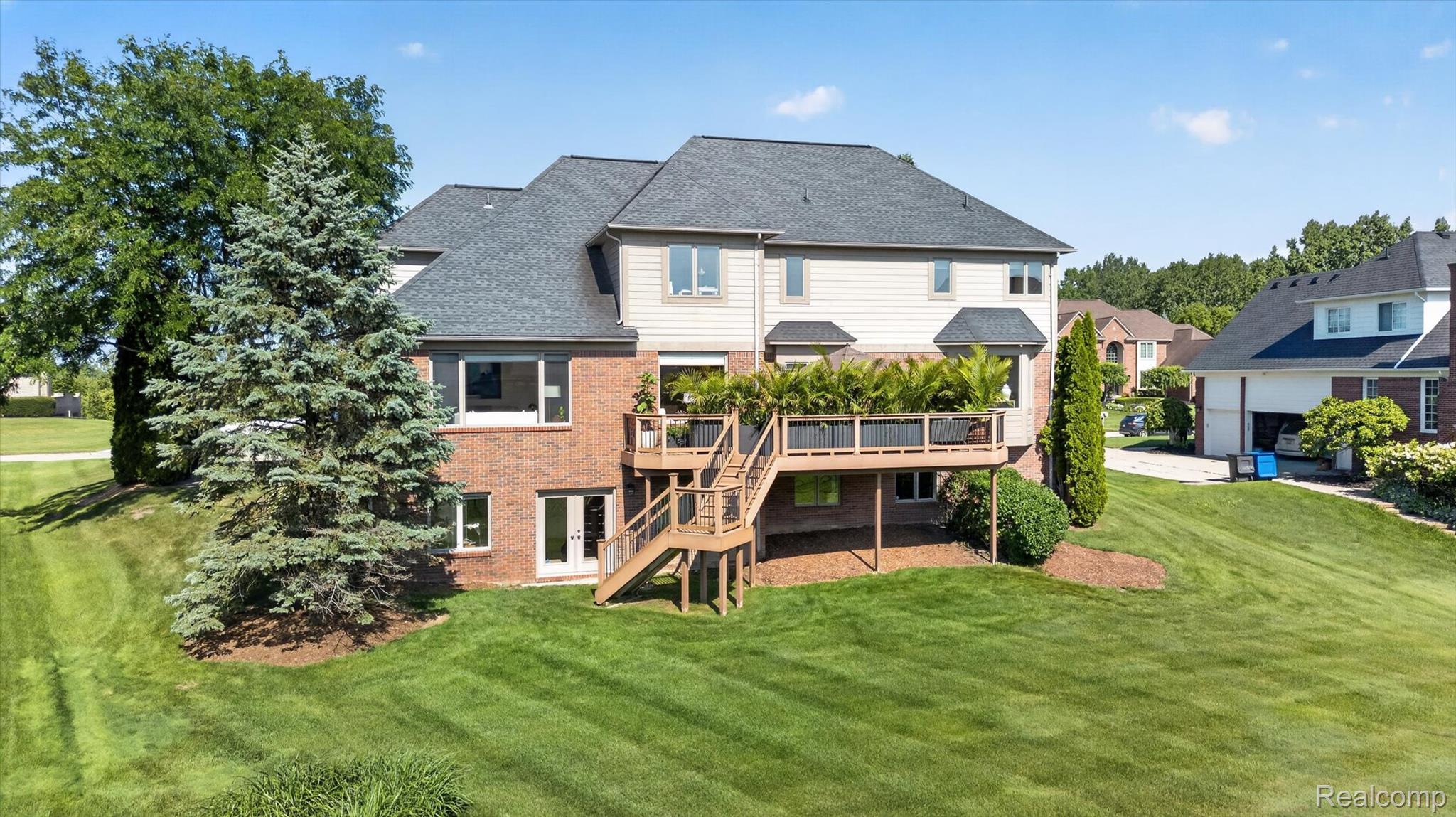 3804 Elk Drive Rochester, MI 48306 - Photo 63 of 75 Rear exterior featuring a multi-level wood deck with stairs, brick and siding facade, and mature landscaping