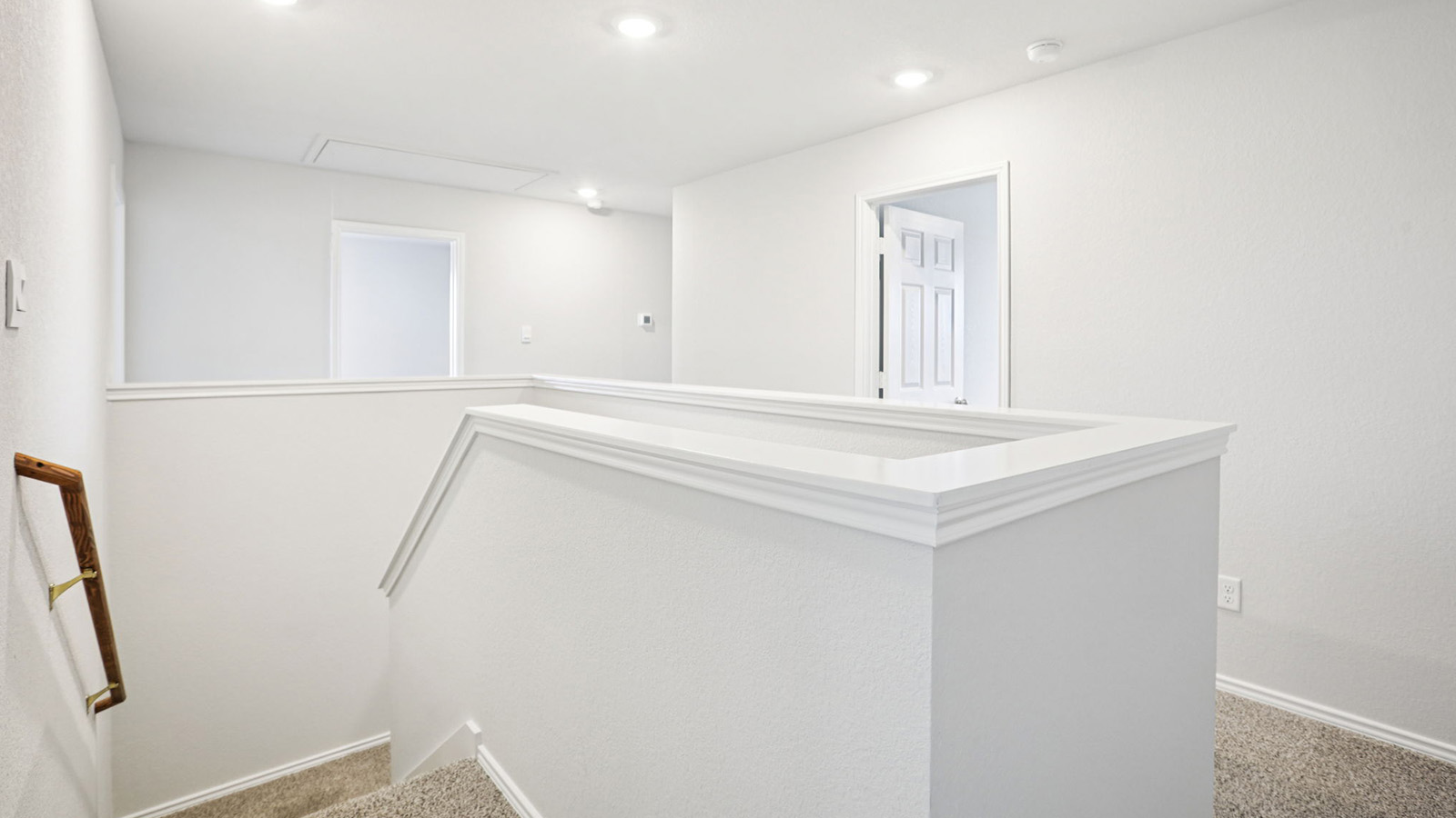 133 Wyatt Way Jarrell, TX 76537 - Photo 14 of 32 Upper-level landing featuring recessed lighting, a white painted half-wall with detailed cap molding, and a carpeted staircase with a wood handrail