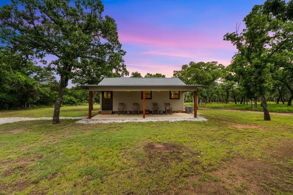 304 County Road 340 Ranger, TX 76470 - Photo 2 of 30 Single-story structure with a covered front porch featuring wooden support beams, a metal roof, and light-toned siding