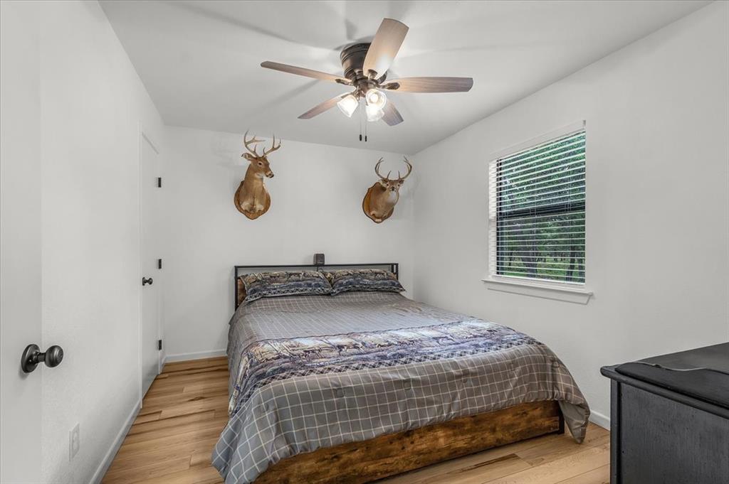 304 County Road 340 Ranger, TX 76470 - Photo 9 of 30 Bright room featuring light wood-finish flooring, white walls, and a ceiling fan with integrated lighting