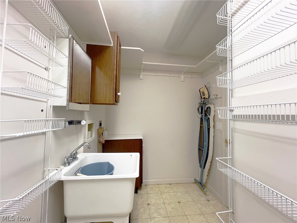 5203 Ridgeland Street Lorain, OH 44055 - Photo 18 of 39 Washroom featuring light tile floors, sink, and cabinets