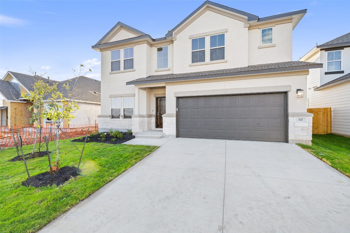 a front view of a house with a yard and garage