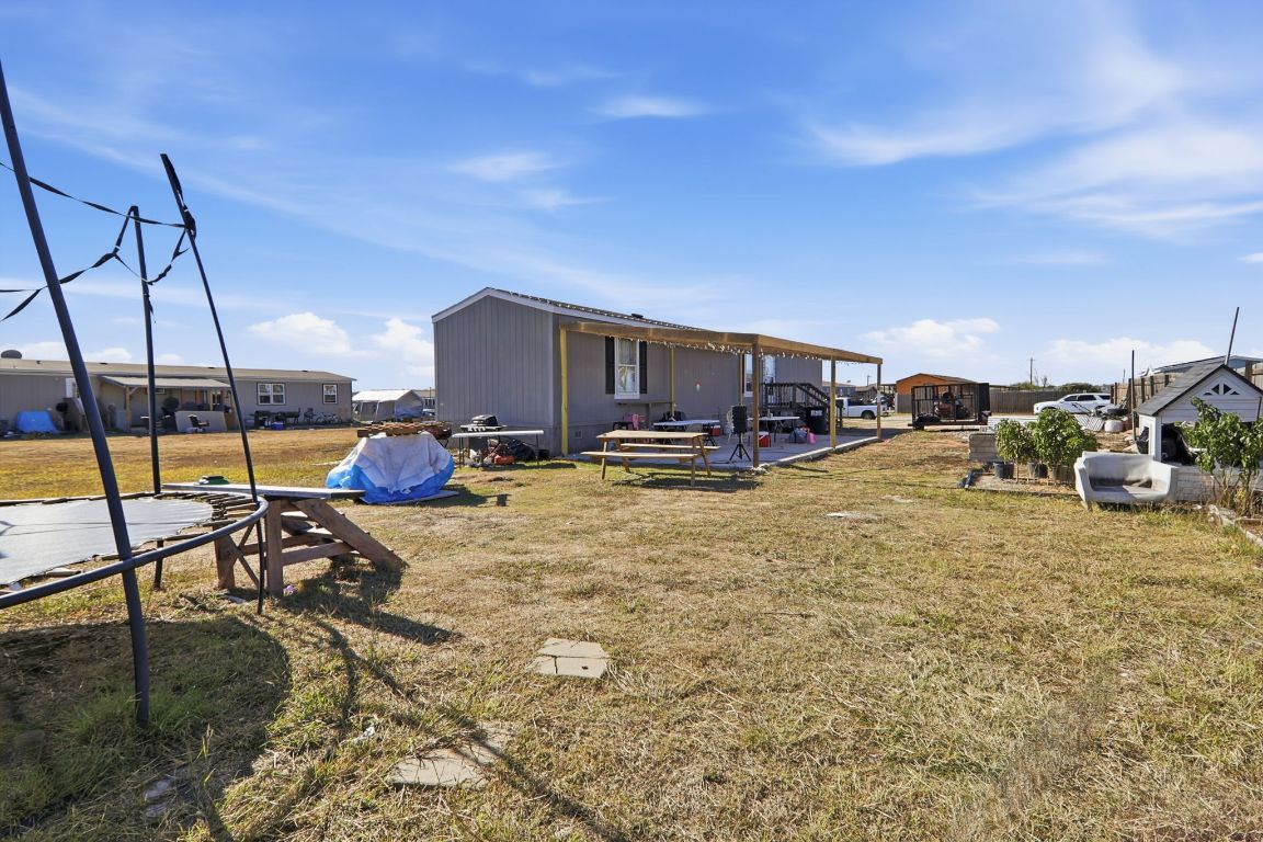 1130 Rustler Pass Kyle, TX 78640 - Photo 20 of 21 View of green lawn with a patio area and a trampoline