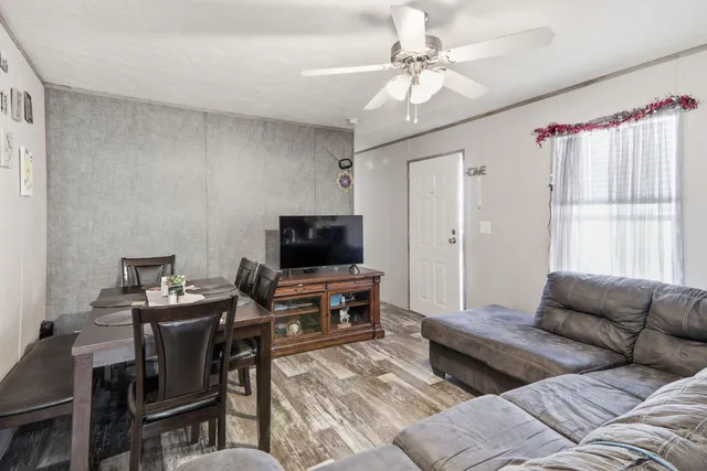 a living room with furniture a flat screen tv and a window